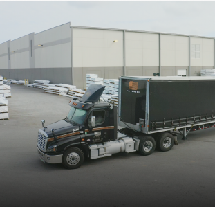 US Lumber Semi truck in font of warehouse.